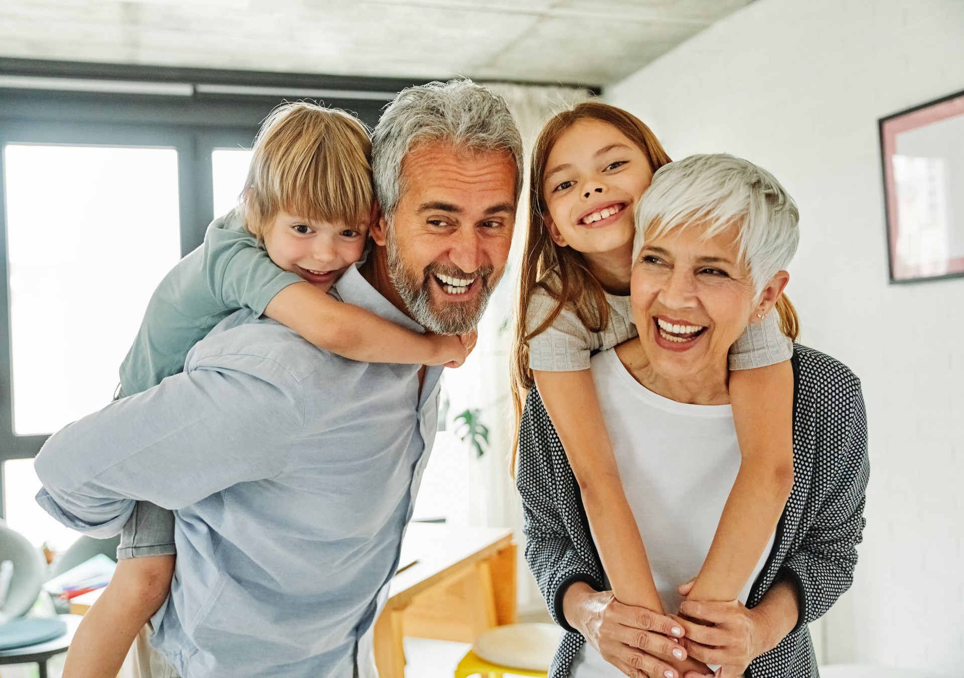 grandchild family child grandparent man woman grandfather happy together grandmother girl senior boy smiling granddaughter piggyback